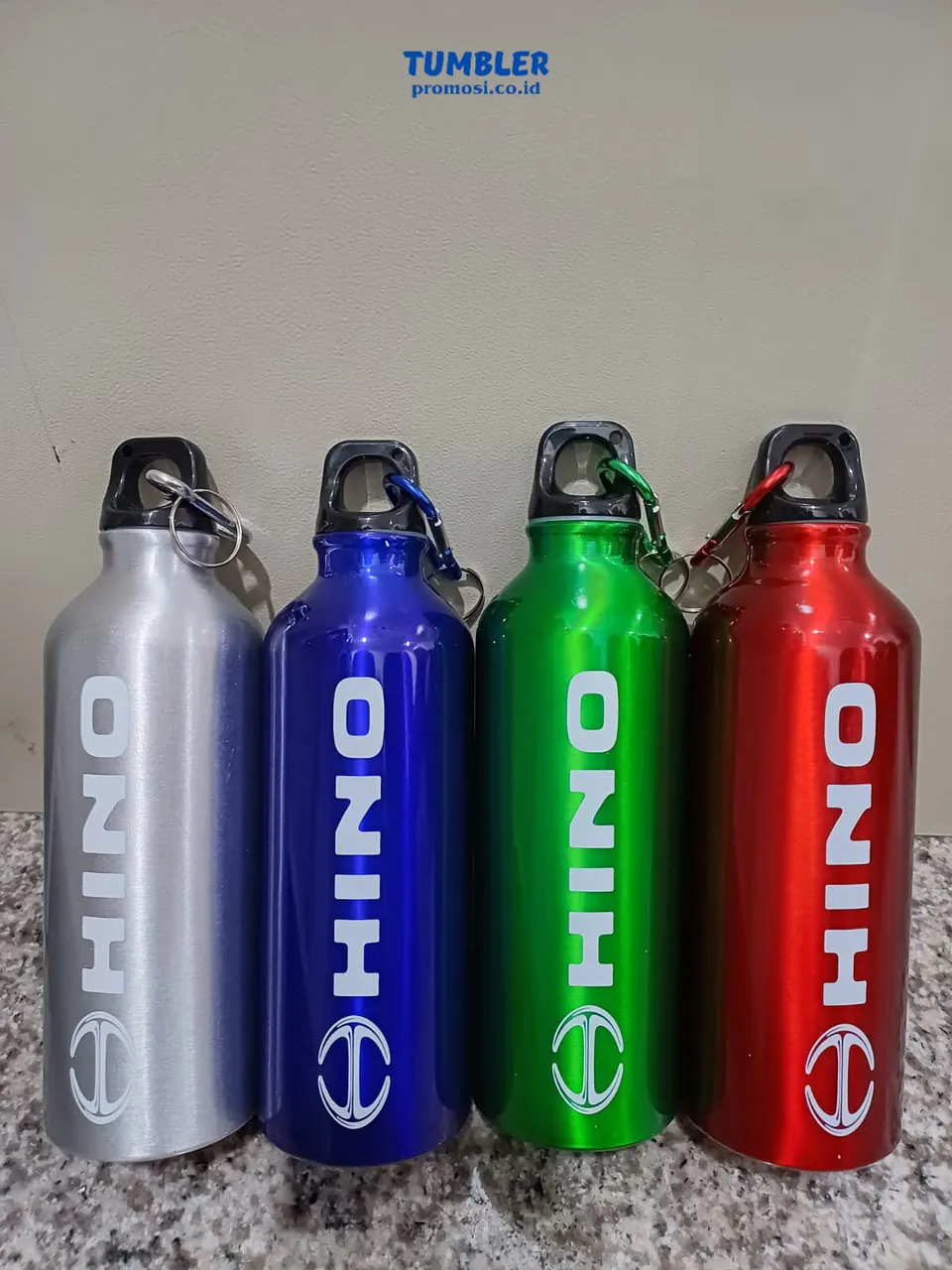 Empat tumbler custom warna abu-abu, biru, hijau, dan merah dengan desain putih