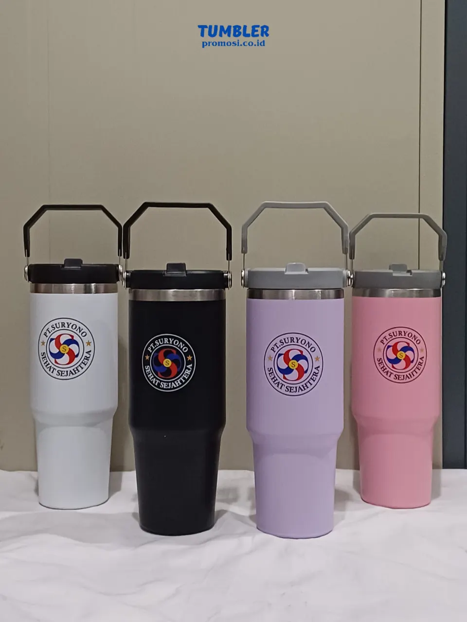 Empat tumbler bertutup pegangan dalam warna hitam, putih, ungu, dan merah muda